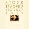 A financial trader analyzing charts and data from the Stock Trader's Almanac.