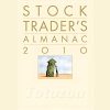 A financial trader analyzing charts and data from the Stock Traders Almanac.