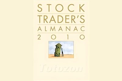 A financial trader analyzing charts and data from the Stock Traders Almanac.