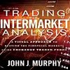 A trader analyzing intermarket relationships on a computer screen, illustrating John Murphy's techniques.