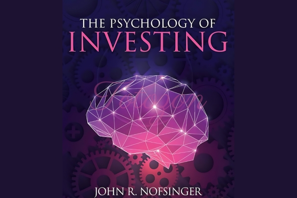 Investor analyzing charts and data, representing the psychological aspects of investing.