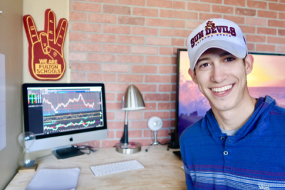 A trader analyzing stock charts on a computer screen, learning trading strategies